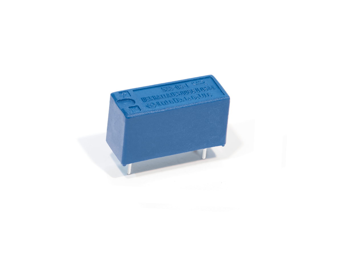 A small blue rectangular 522 Series Optocouplers relay component with four metal pins protruding from the bottom, placed on a white background. by Standex Detect