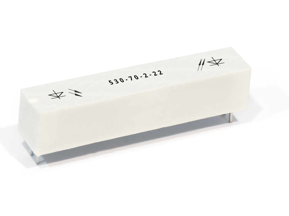 A white rectangular 530-70 Series Optocouplers component with metal pins at the bottom, labeled 530-70-2-22 on top, and marked with diode symbols on both ends. by Standex Detect