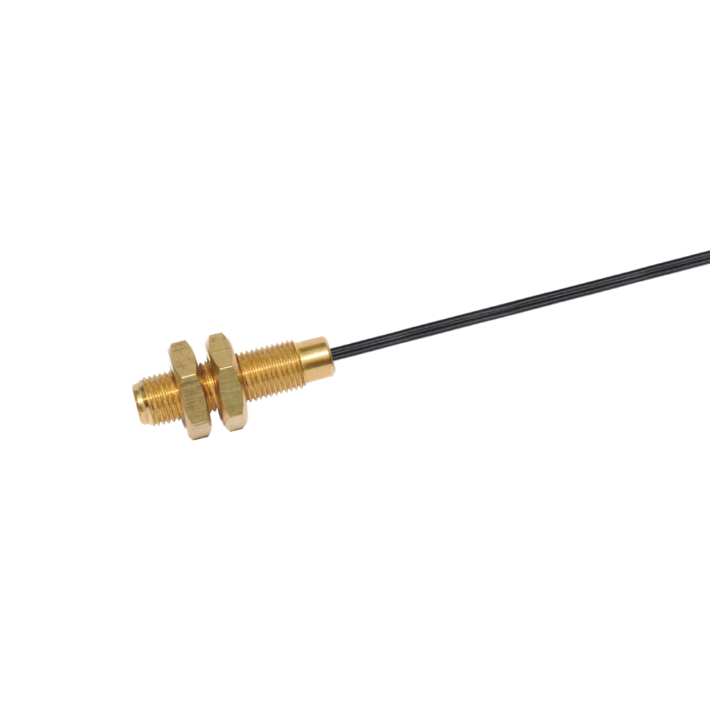 A brass threaded RF coaxial connector with threaded housing, two hex nuts, and a black cable attached, shown against a white background. by Standex Detect