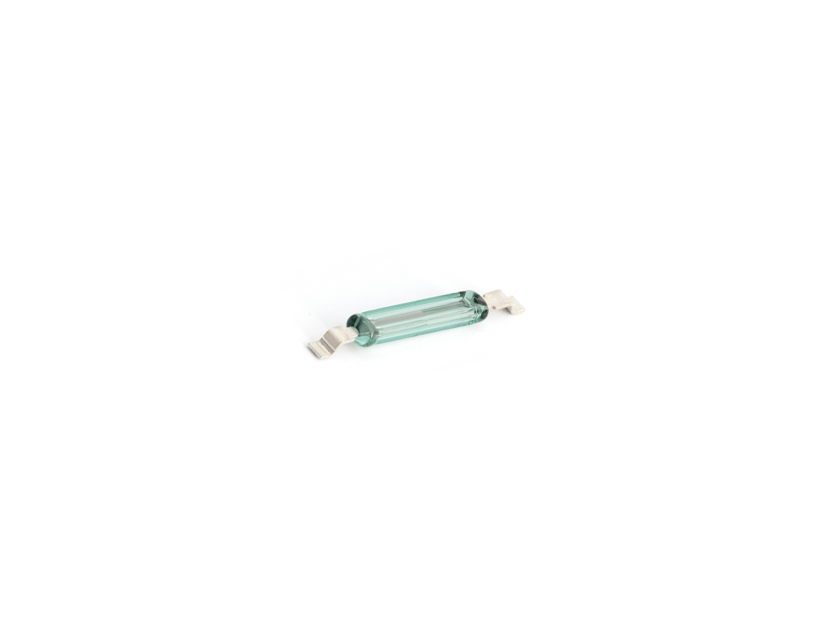 A small glass fuse with metal end caps, similar in size to a MK23-35 Reed Switch, sits on a white background. The cylindrical, transparent body reveals its internal filament. by Standex Detect