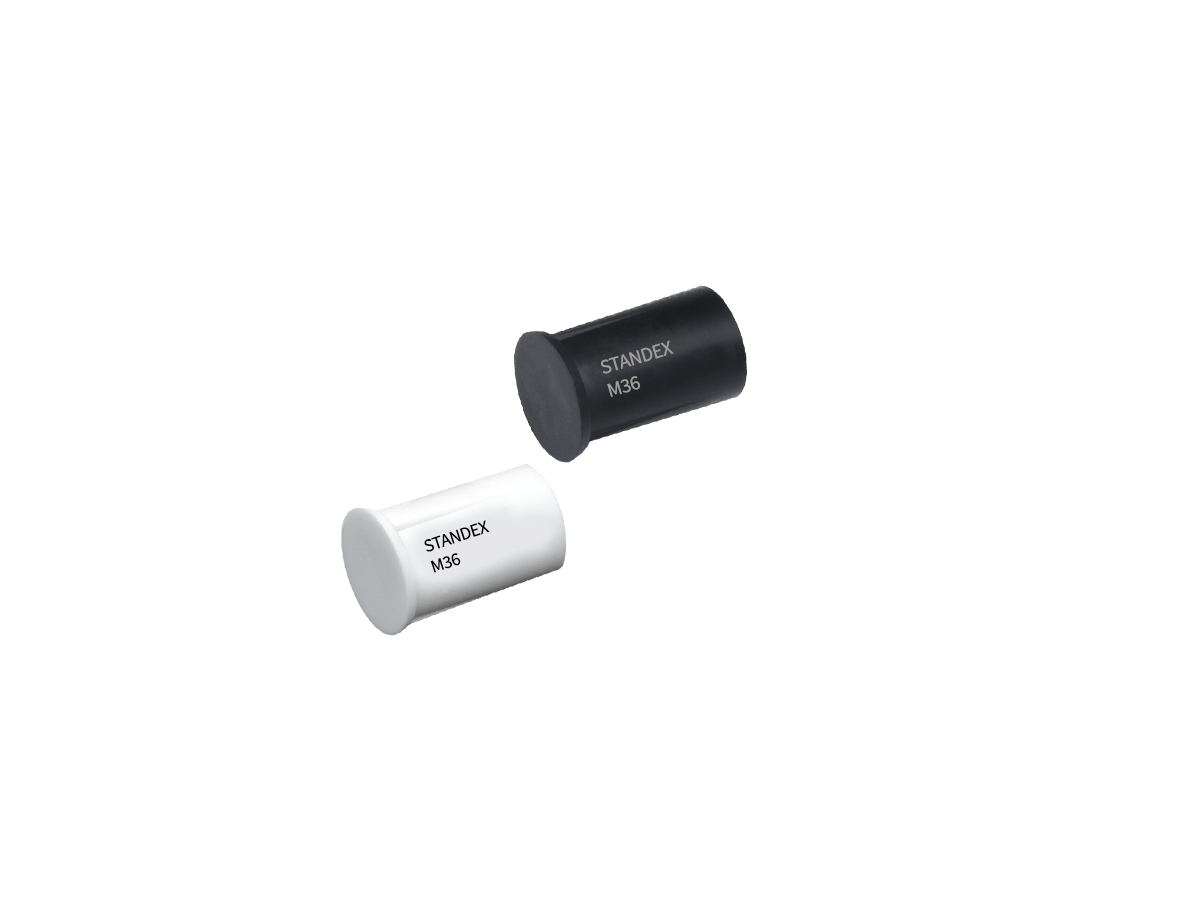 Two cylindrical electronic components, one black and one white, each labeled STANDEX M36, from the M36 Series Magnet range, are positioned diagonally on a plain white background. by Standex Detect